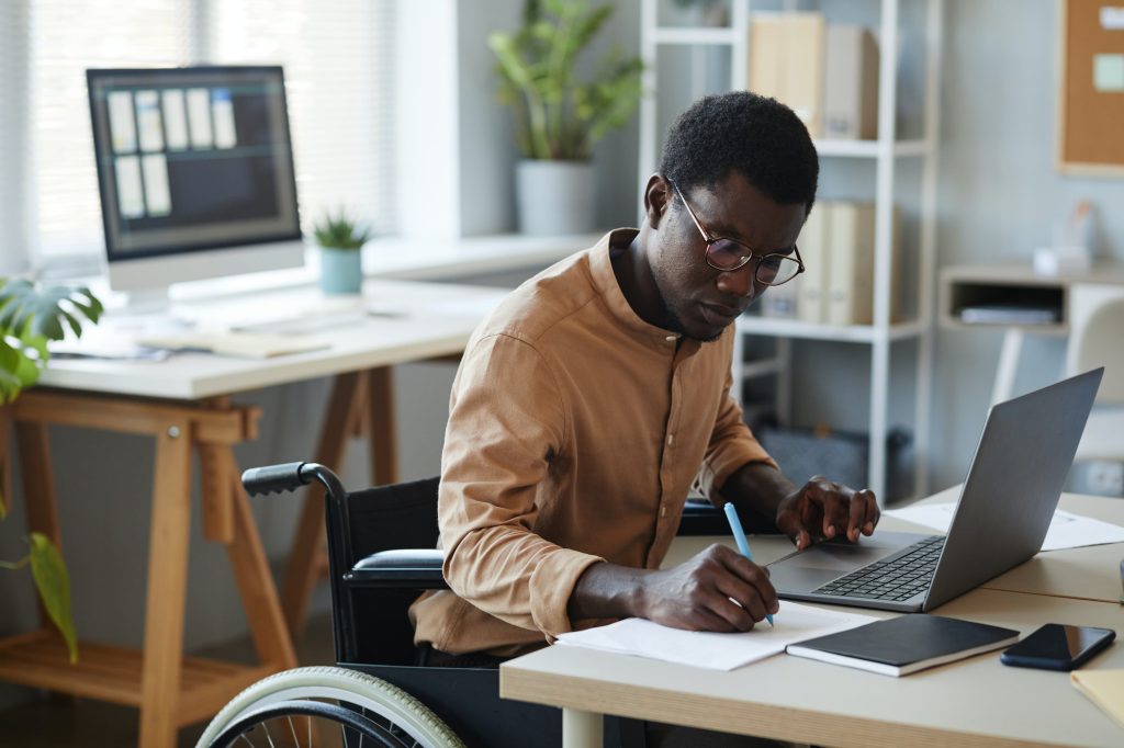 Black Young Man With Disability in Office