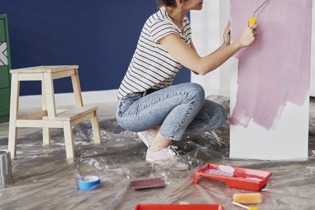 Young woman repainting furniture with DIY