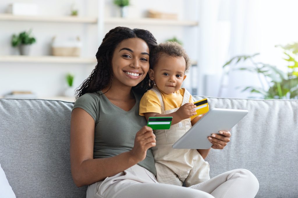 Online Payments. Black Mom And Child Using Digital Tablet And Credit Cards