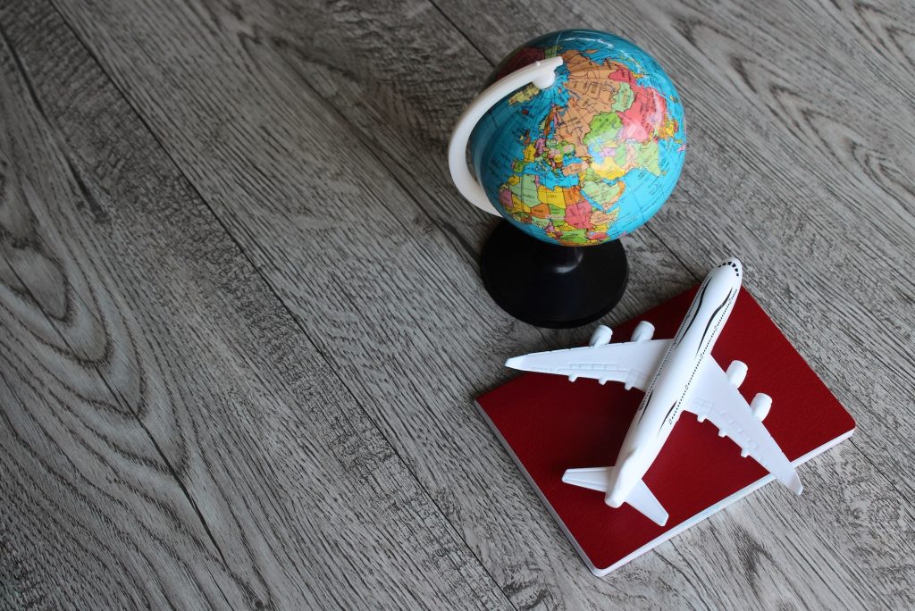 Selective focus image of world globe, toy plane and passport with copy space.