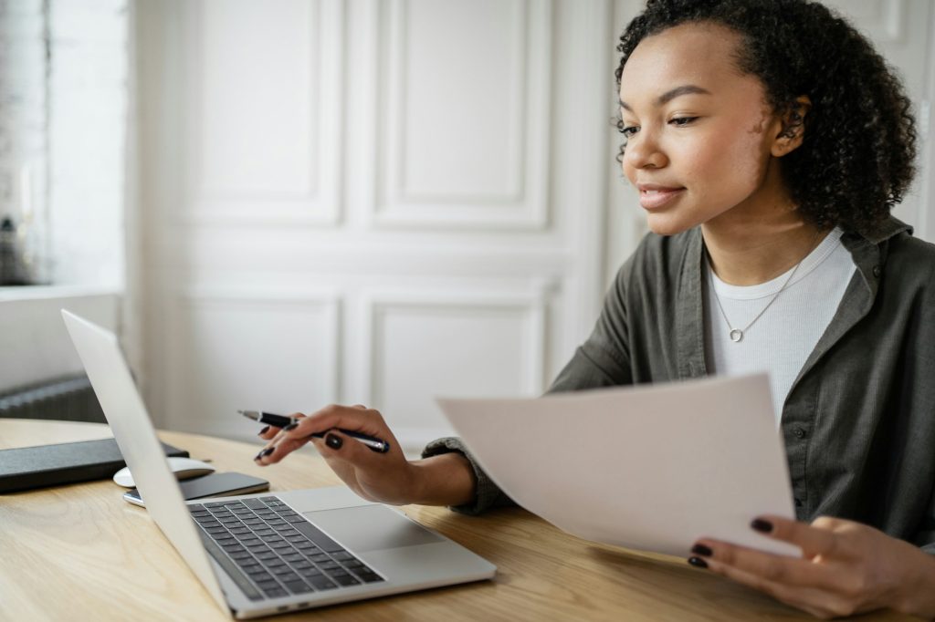 A female financier uses a laptop to work in an office. Coworking space company finance report.